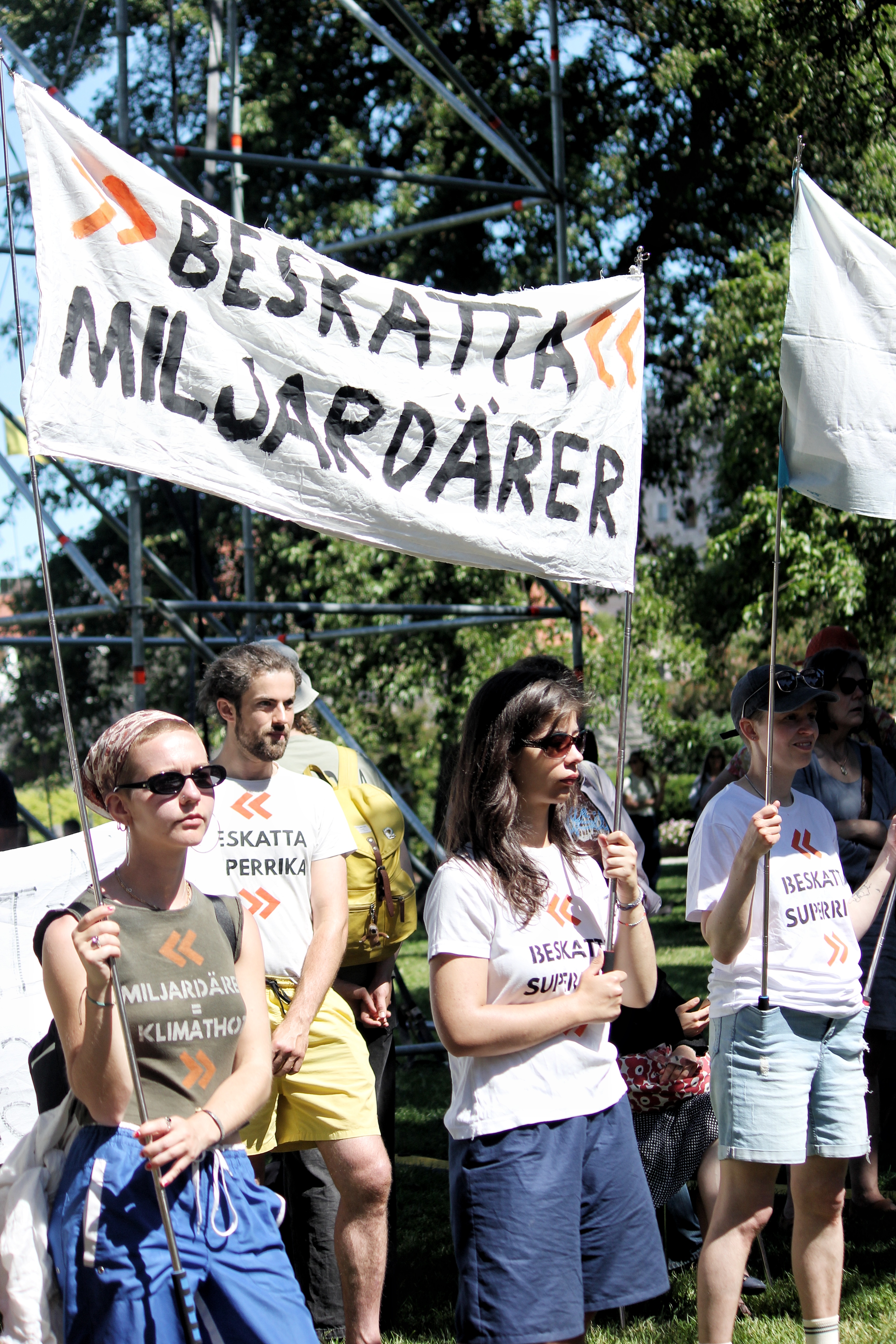 Jag och tre andra aktivister står med banderoller med texten "Beskatta Miljardärer"